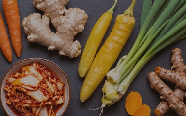 Frische Zutaten für den Kochkurs: Karotten, Ingwer, Kurkuma, Frühlingszwiebeln und fermentiertes Gemüse